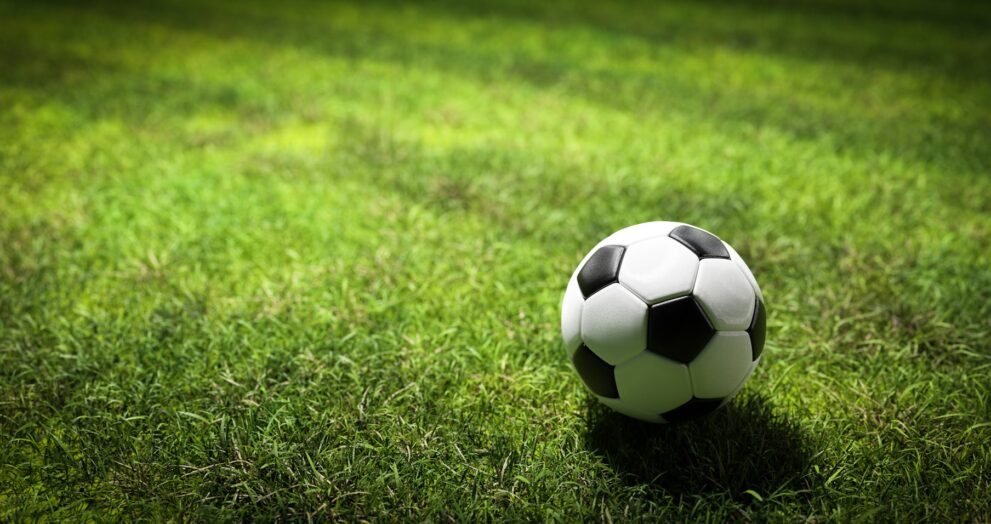 Football soccer ball on grass field