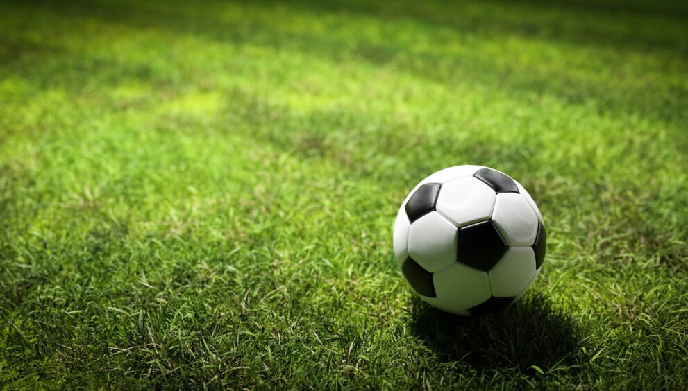 Football soccer ball on grass field